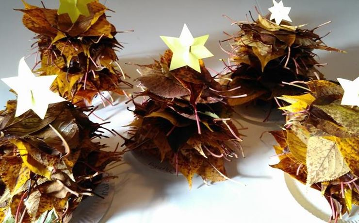 Blade på pinde ligner juletræer med en stjerne af gult papir i toppen.